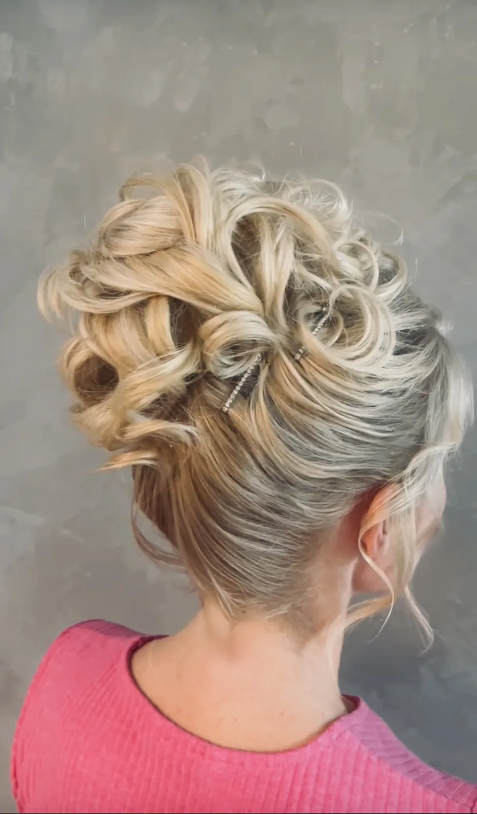 Full updo worn with hair extensions, attachment points hidden
